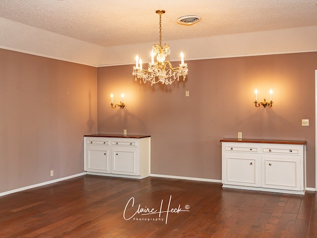 1209 W Pecan Ave, Midland, TX 79705 - unfurnished dining area featuring a chandelier, dark wood-style floors, baseboards, and a textured ceiling