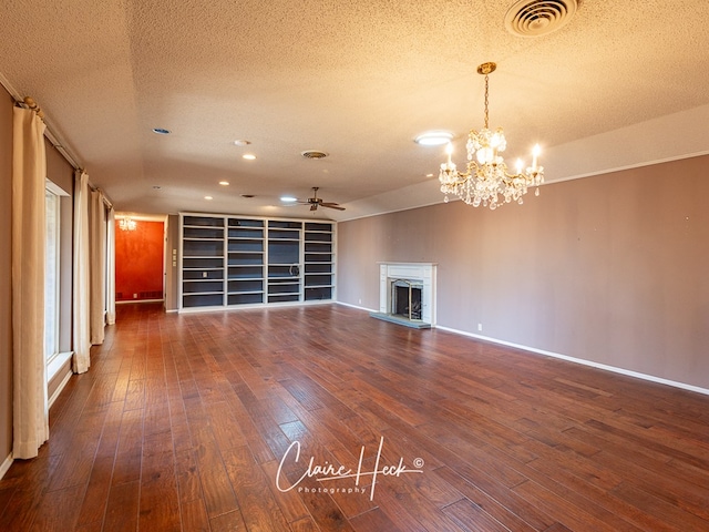 1209 W Pecan Ave, Midland, TX 79705 - unfurnished living room featuring ceiling fan, a textured ceiling, dark wood-style flooring, a fireplace with raised hearth, and baseboards