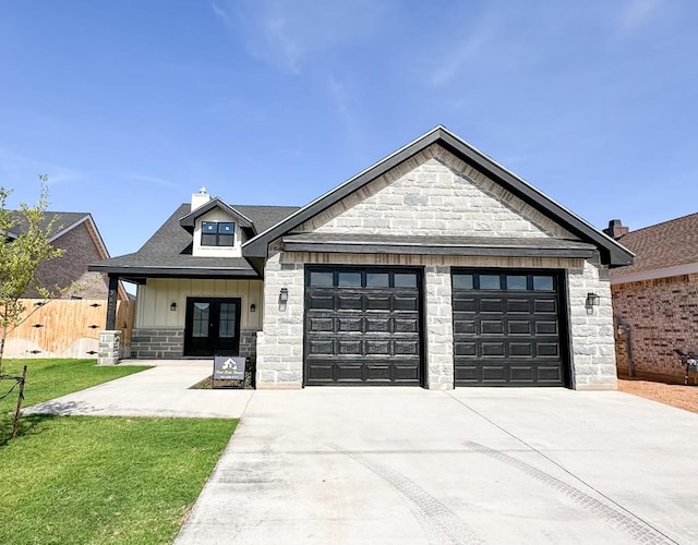 view of front facade featuring a front yard, french doors, and a garage