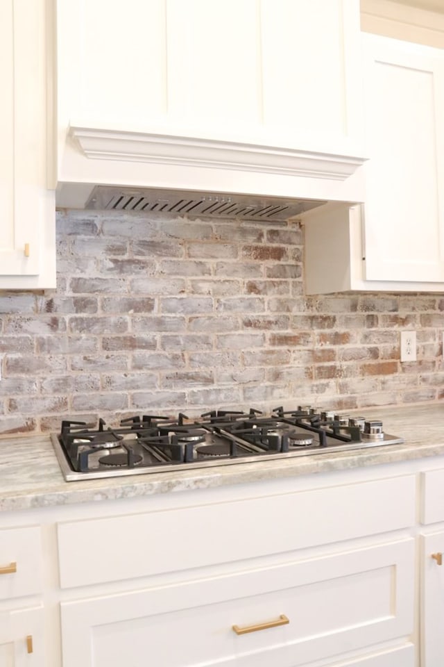 3624 Yorkshire Dr, Odessa, TX 79765 - kitchen with white cabinets, decorative backsplash, and stainless steel gas stovetop