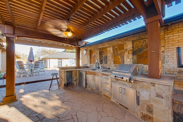 view of patio featuring an outdoor kitchen, a grill, sink, and ceiling fan