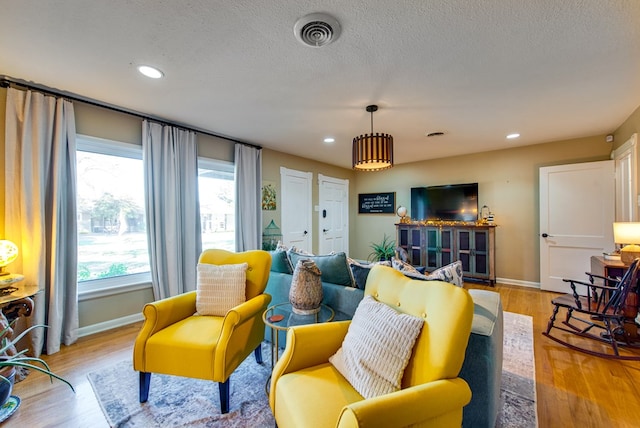 living room featuring a textured ceiling and light wood-type flooring