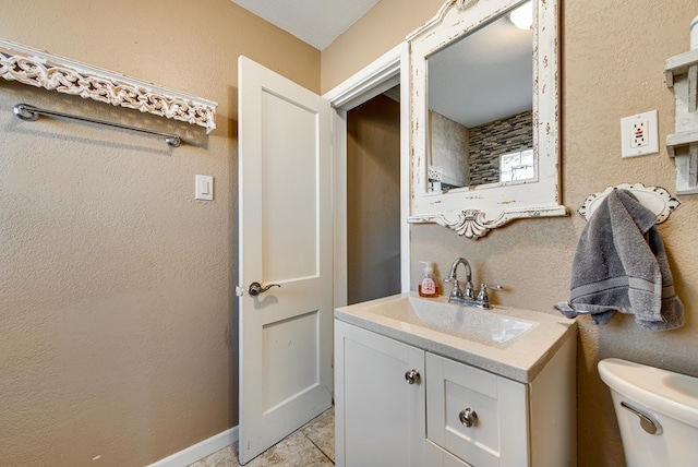 bathroom with tile patterned flooring, vanity, and toilet