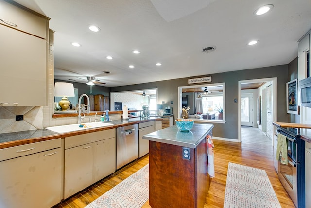 kitchen with a center island, light wood-type flooring, stainless steel appliances, and sink