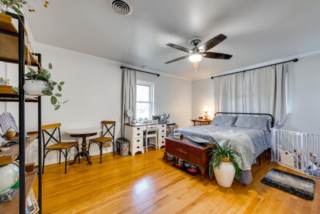 bedroom with ceiling fan, ornamental molding, and light hardwood / wood-style flooring