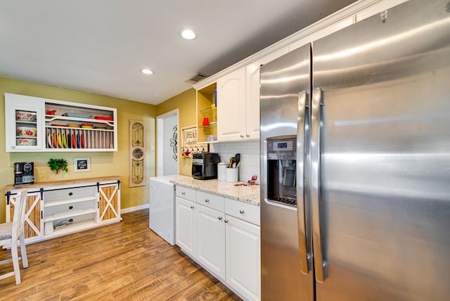 kitchen featuring backsplash, light hardwood / wood-style flooring, stainless steel fridge with ice dispenser, light stone countertops, and white cabinetry