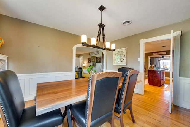 dining room with light hardwood / wood-style flooring and a notable chandelier