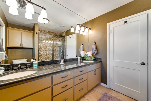 bathroom featuring tile patterned flooring, vanity, toilet, and walk in shower