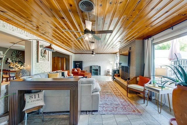 living room featuring ceiling fan, a large fireplace, and wooden ceiling