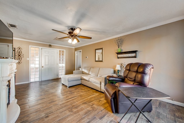 living room with hardwood / wood-style floors, ceiling fan, crown molding, and a textured ceiling