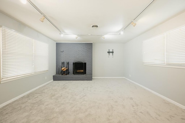 806 Boyd Ave, Midland, TX 79705 - unfurnished living room featuring rail lighting, a fireplace, carpet floors, and baseboards