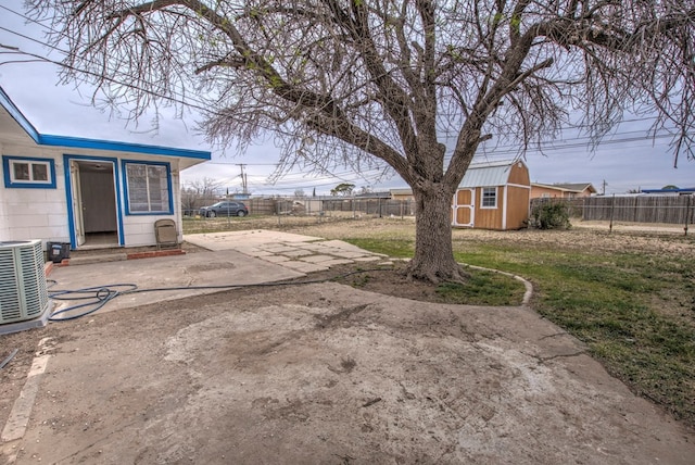 view of yard featuring central air condition unit, a patio, an outbuilding, and a fenced backyard