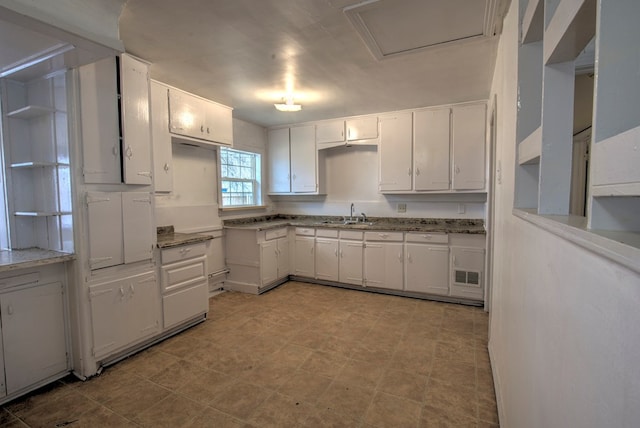 kitchen featuring visible vents, white cabinets, and a sink