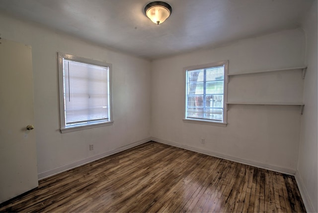 empty room with baseboards and hardwood / wood-style flooring