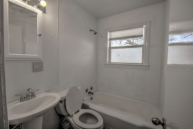 bathroom featuring toilet,  shower combination, and a sink