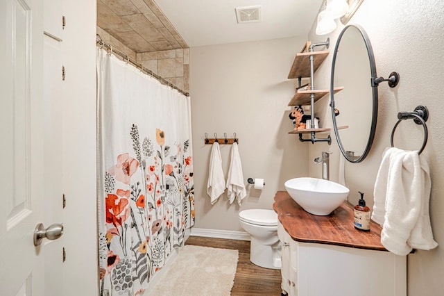 bathroom with vanity, hardwood / wood-style flooring, toilet, and walk in shower