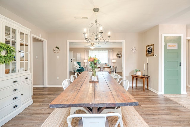 dining area with light wood-type flooring and a chandelier