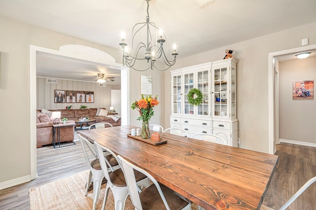 dining area featuring ceiling fan with notable chandelier and light wood-type flooring