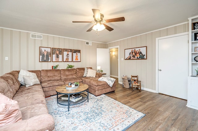 living room featuring a textured ceiling, hardwood / wood-style flooring, ceiling fan, and crown molding