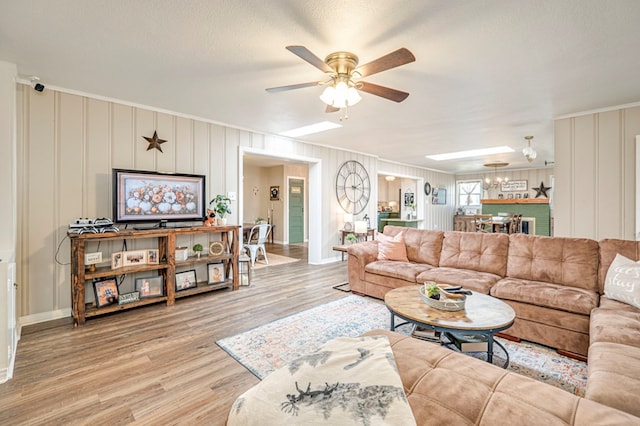 living room with wood-type flooring, a textured ceiling, and ceiling fan