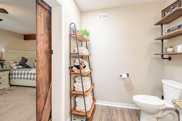 bathroom featuring hardwood / wood-style flooring and toilet