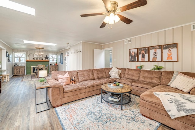 living room with hardwood / wood-style flooring, ceiling fan, ornamental molding, and a textured ceiling