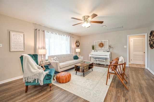 living room featuring ceiling fan and dark wood-type flooring