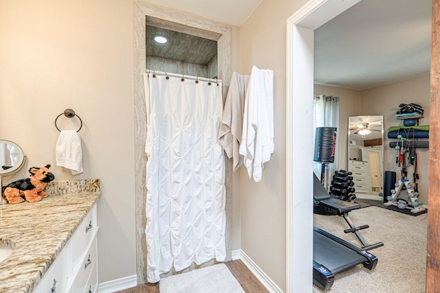 bathroom with hardwood / wood-style floors, vanity, ceiling fan, and curtained shower