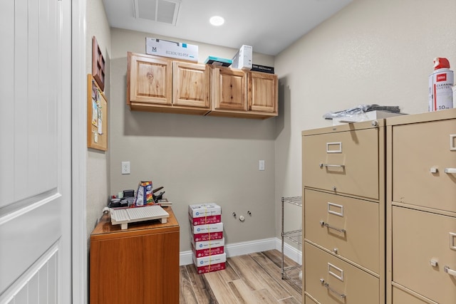 laundry area with cabinets and light hardwood / wood-style floors