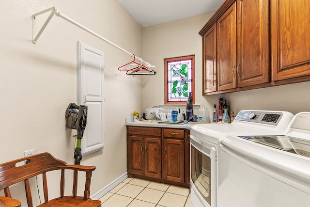 laundry area featuring light tile patterned flooring, cabinets, and independent washer and dryer