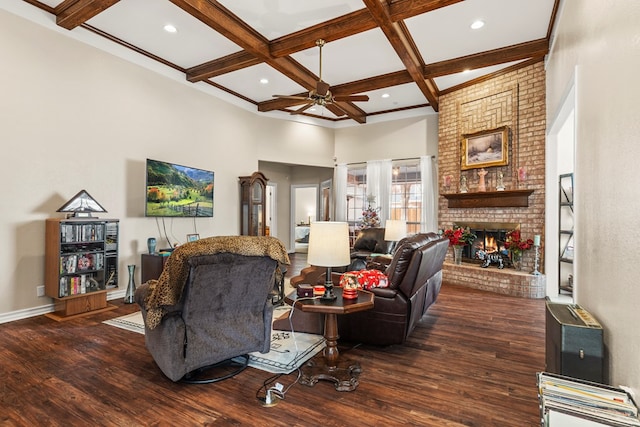 living room featuring coffered ceiling, ceiling fan, dark wood-type flooring, beam ceiling, and a fireplace