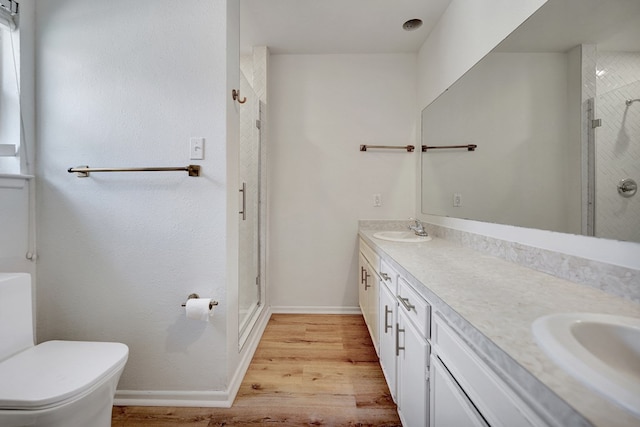 2408 Goddard Ct, Midland, TX 79705 - bathroom featuring a stall shower, double vanity, and wood finished floors