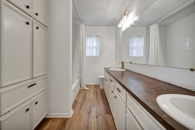 2408 Goddard Ct, Midland, TX 79705 - full bath with double vanity, wood finished floors, and shower / bathtub combination with curtain