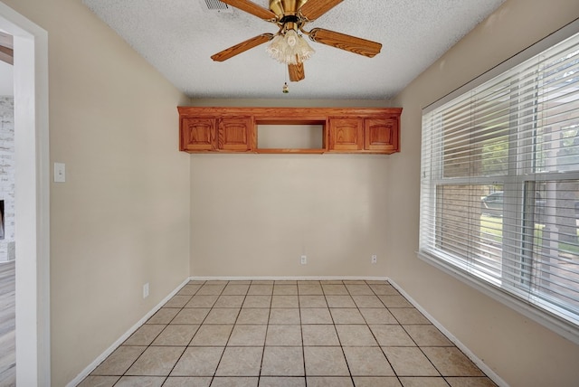 2408 Goddard Ct, Midland, TX 79705 - spare room featuring light tile patterned flooring, a ceiling fan, and a textured ceiling