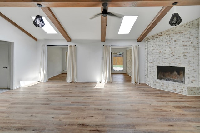 2408 Goddard Ct, Midland, TX 79705 - unfurnished living room with a ceiling fan, wood finished floors, a skylight, and a fireplace