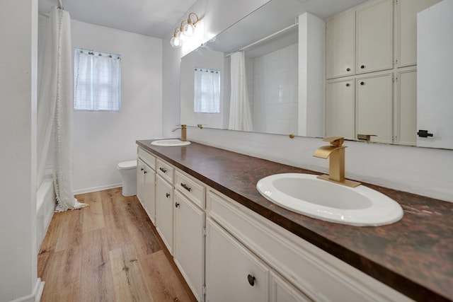 2408 Goddard Ct, Midland, TX 79705 - full bath with double vanity, wood finished floors, and shower / bathtub combination with curtain