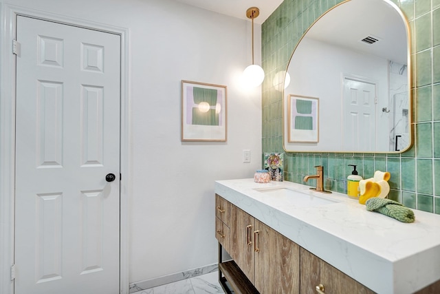 bathroom with vanity, tasteful backsplash, marble finish floor, and visible vents