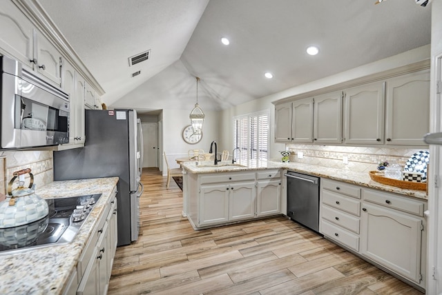 kitchen featuring a peninsula, appliances with stainless steel finishes, visible vents, and tasteful backsplash