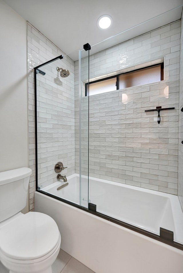 bathroom with tile patterned flooring, toilet, and shower / bath combination with glass door