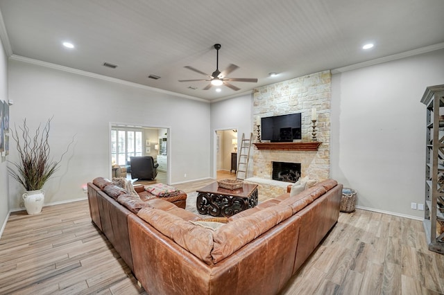 living room with crown molding, light wood-style flooring, a ceiling fan, and visible vents