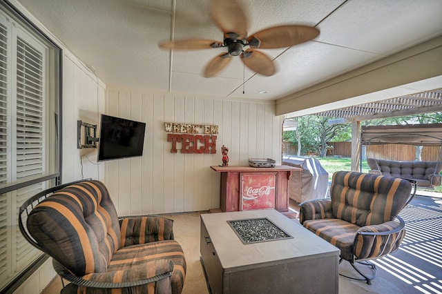 view of patio / terrace with a fire pit, fence, and ceiling fan