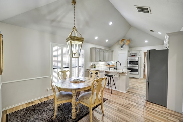 dining space with vaulted ceiling, visible vents, light wood-style flooring, and recessed lighting