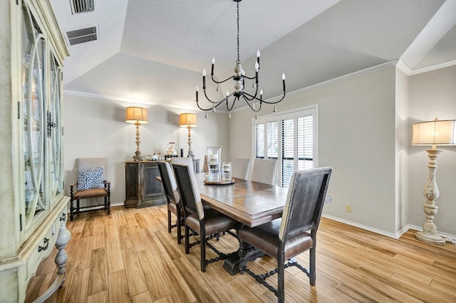 dining room with light wood-style floors, visible vents, an inviting chandelier, and crown molding