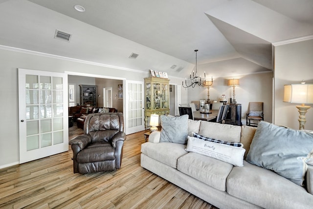 living room with crown molding, visible vents, wood finished floors, and a notable chandelier