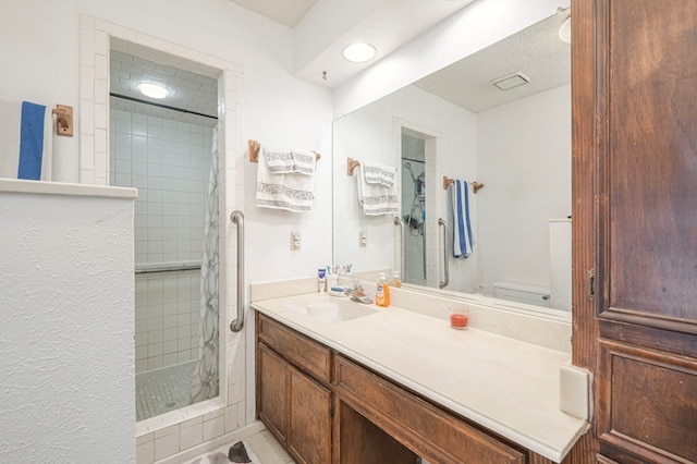 bathroom with vanity, toilet, and a tile shower