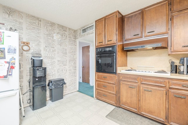 kitchen with white appliances and a textured ceiling