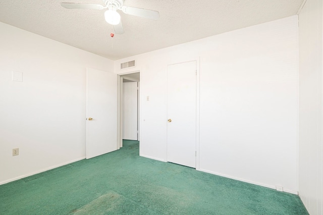 unfurnished room featuring ceiling fan, carpet floors, and a textured ceiling