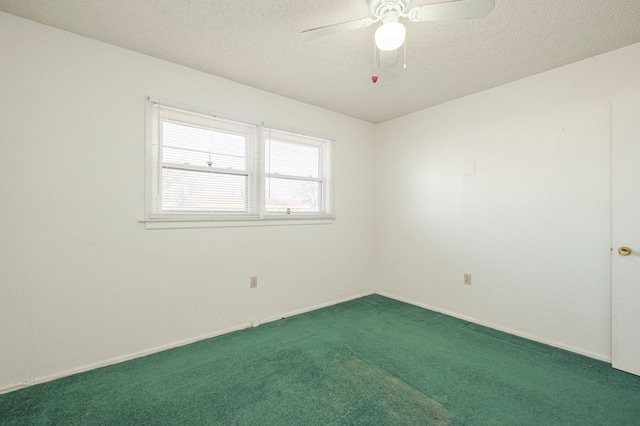 empty room with ceiling fan, dark carpet, and a textured ceiling