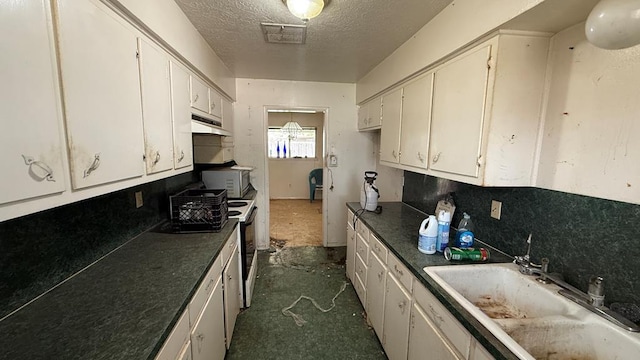 3603 Sinclair Ave, Midland, TX 79707 - kitchen with a textured ceiling, tasteful backsplash, white cabinetry, dark countertops, and under cabinet range hood