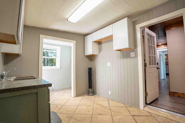 2950 Ranch Road 33, Big Spring, TX 79720 - kitchen with dark countertops, white cabinets, and wooden walls